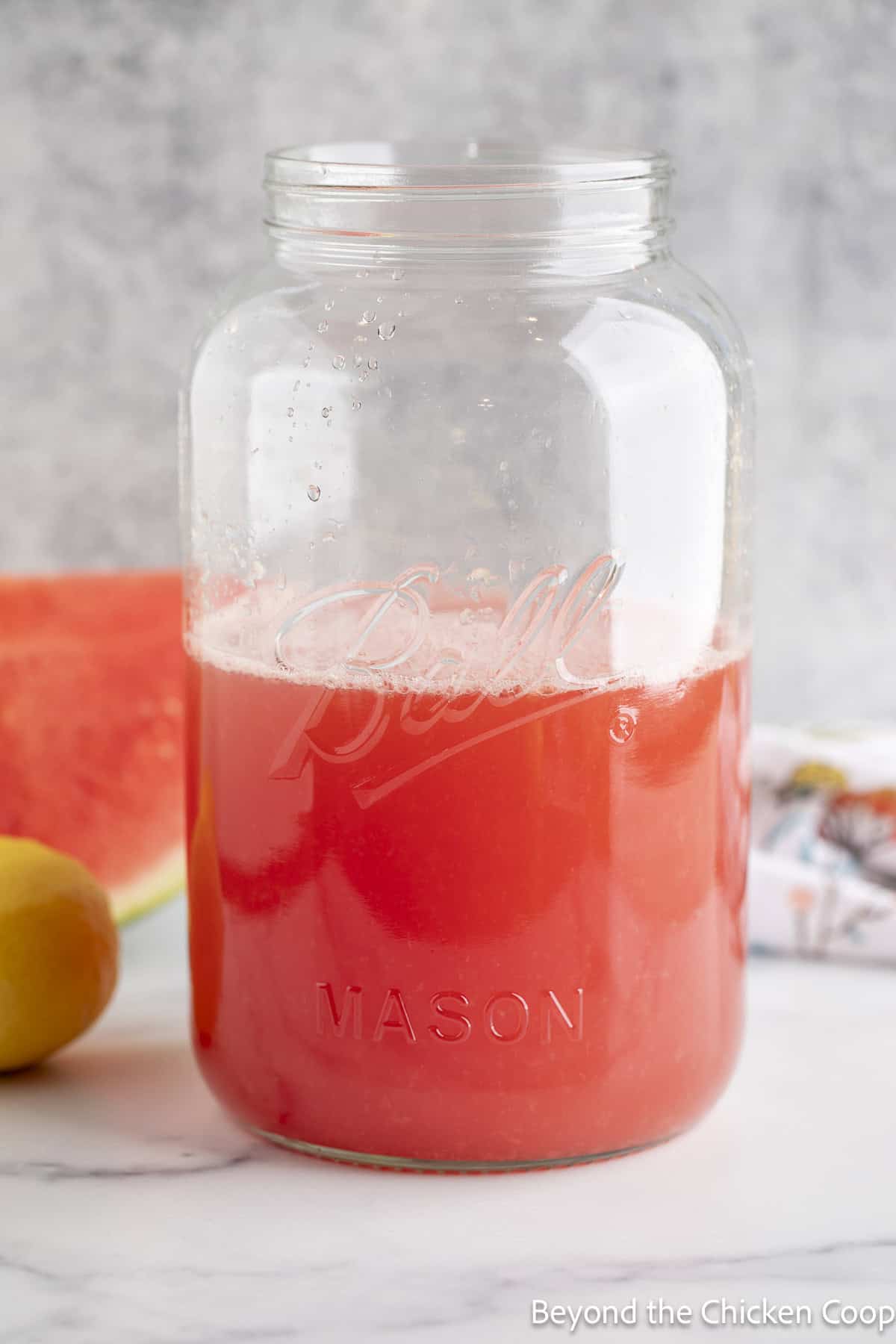 A jar filled with a pink lemonade.