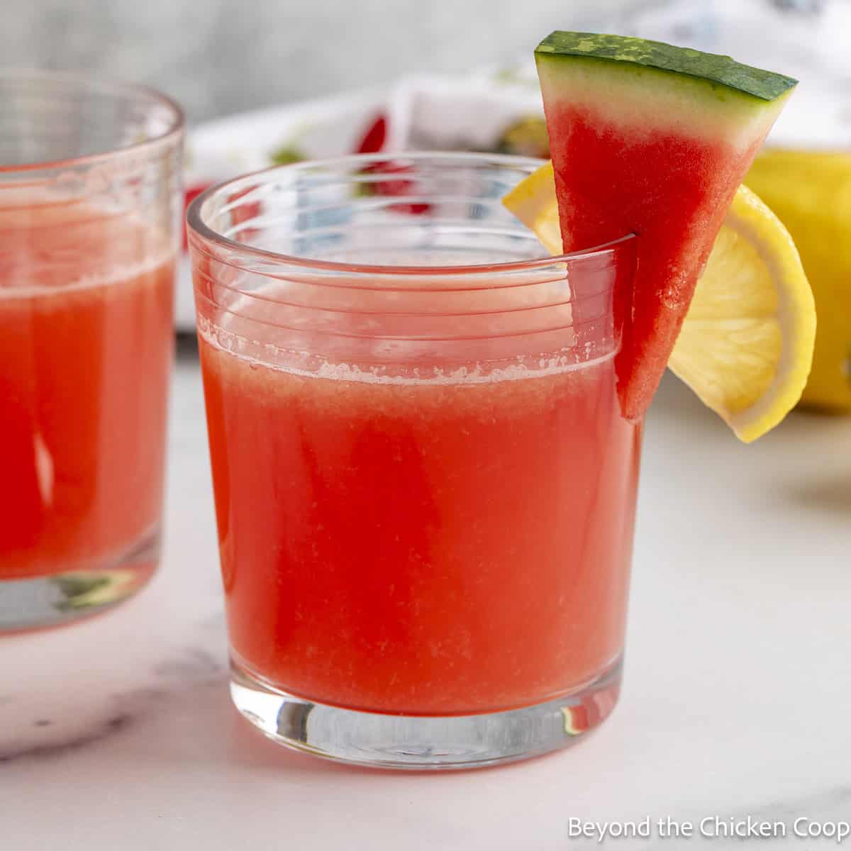 Watermelon Lemonade in a glass with a small watermelon wedge as a garnish.
