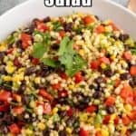 A salad with corn, beans, peppers, and couscous in a white bowl.