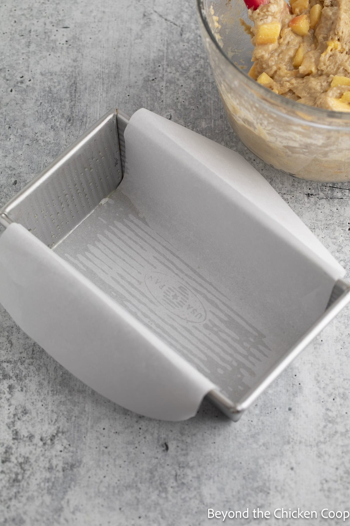 A bread pan lined with parchment paper.
