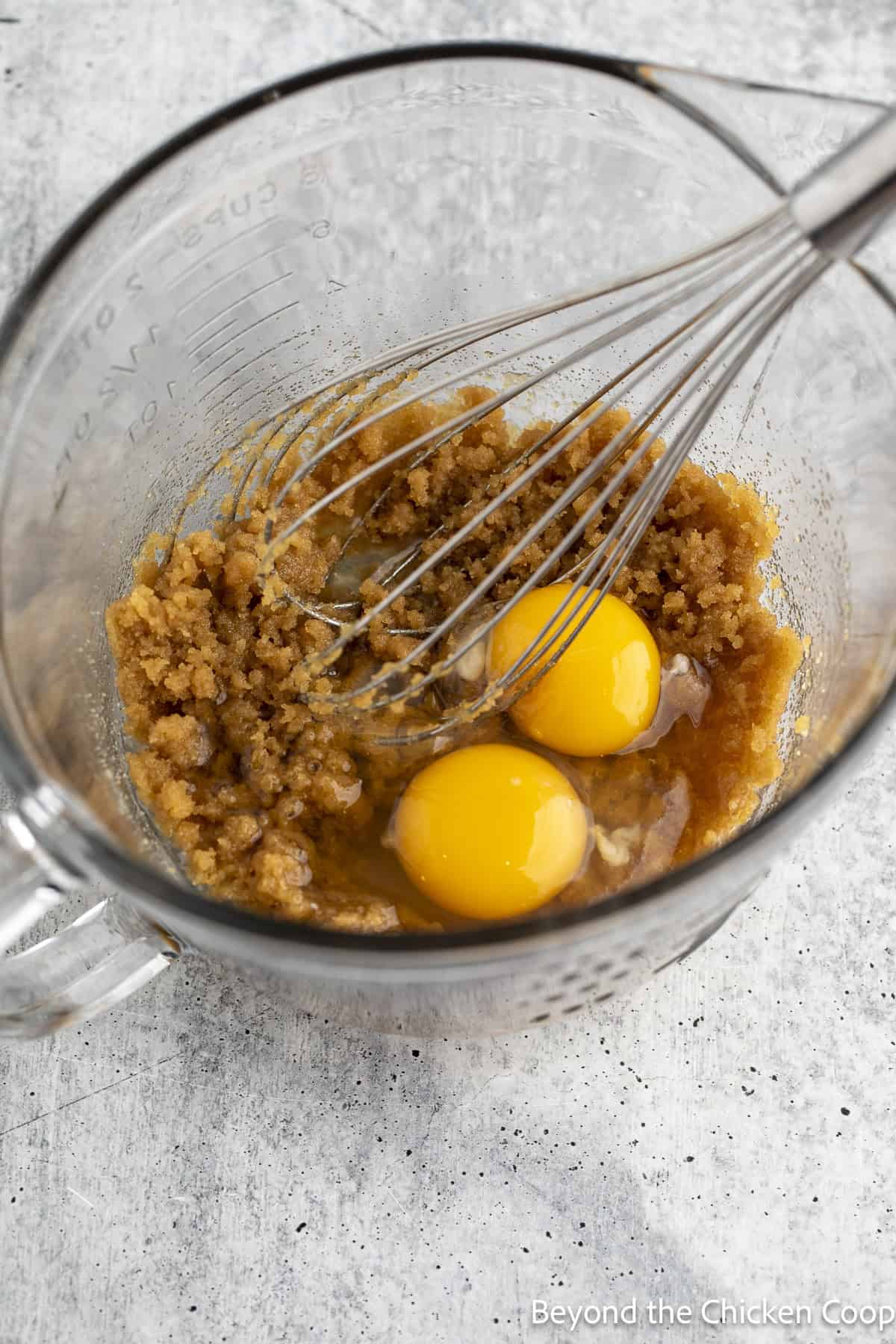 Brown sugar, butter, and eggs in a glass bowl.