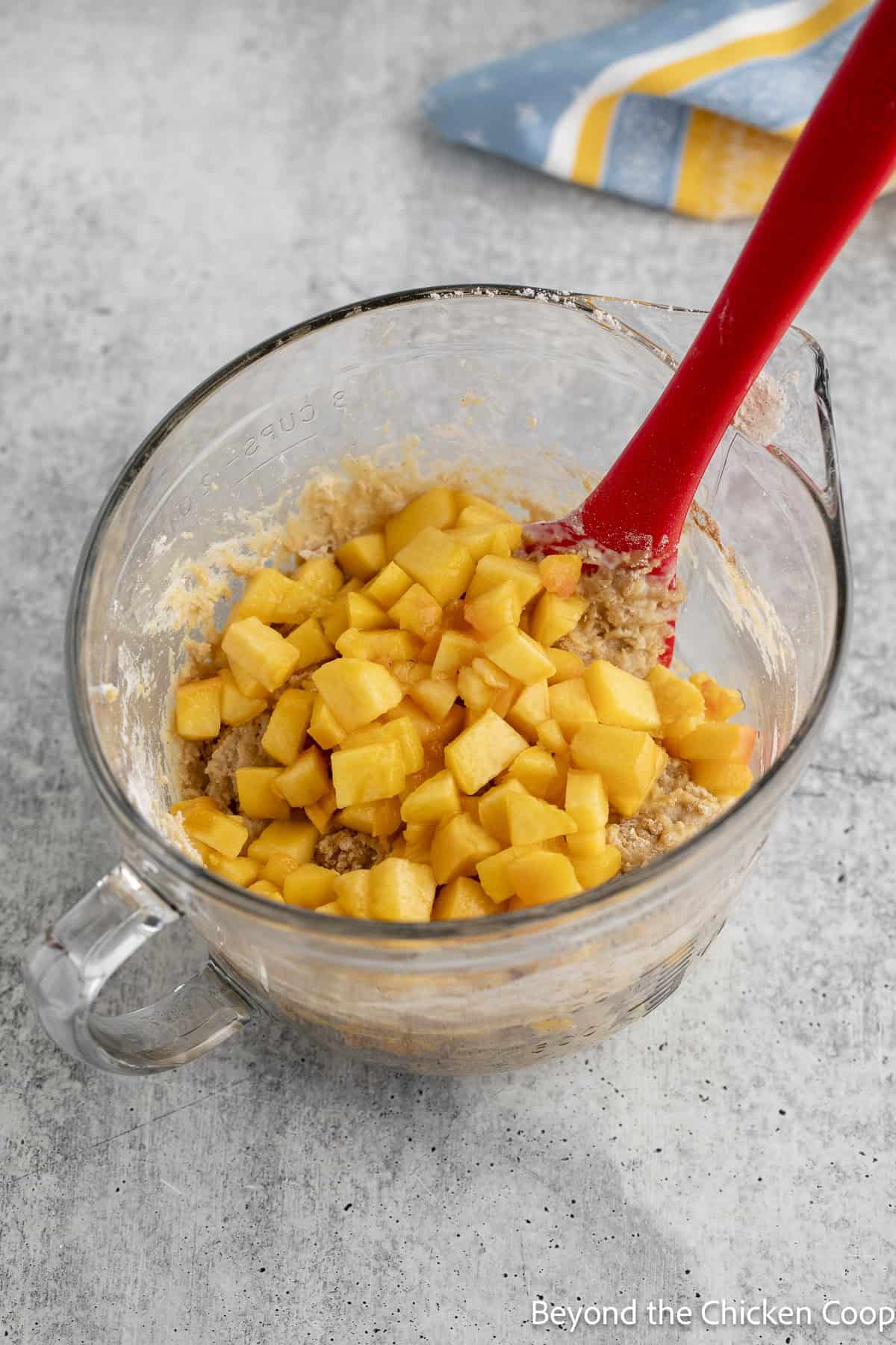 Folding peaches into quick bread batter.