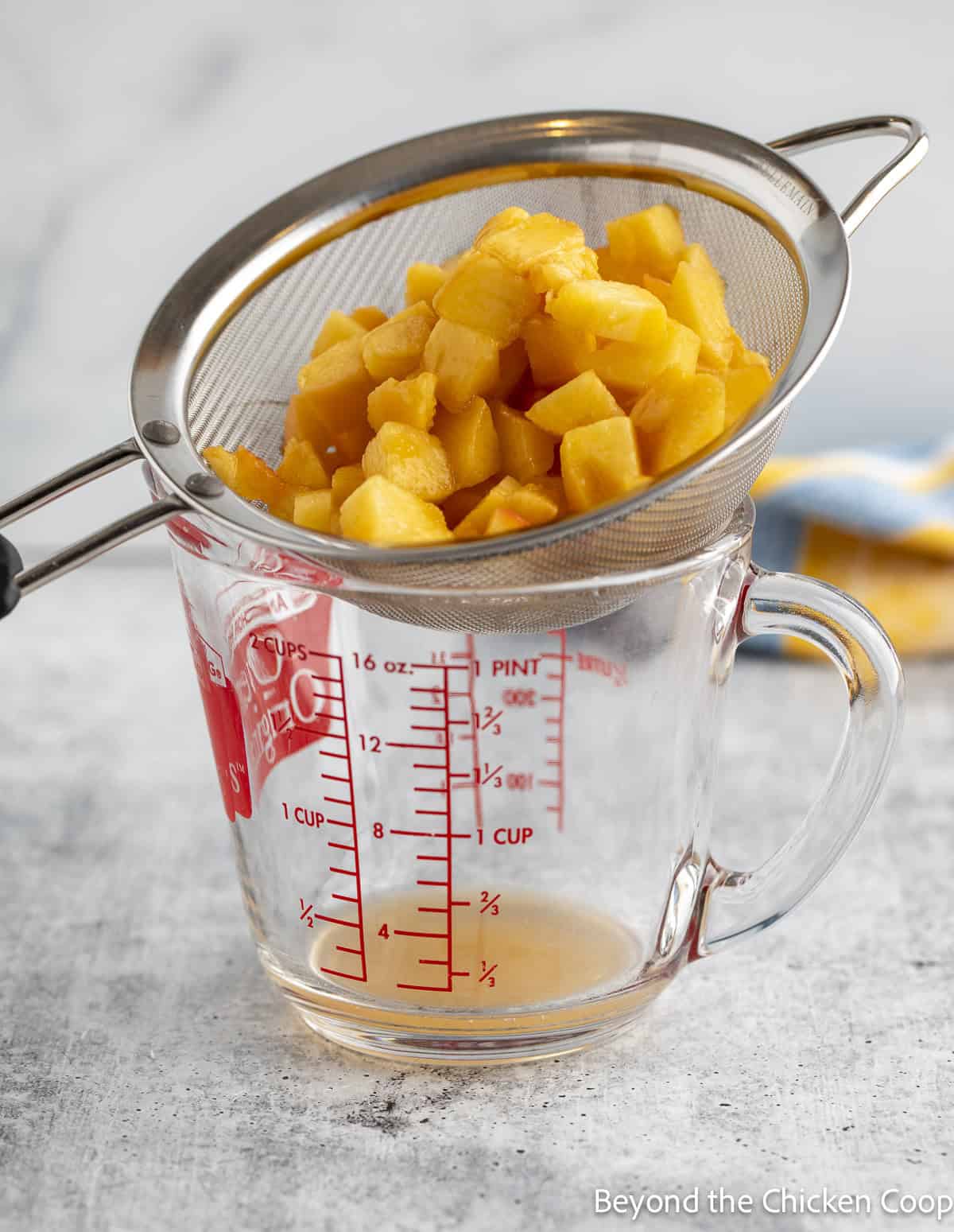 Chopped peaches in a sieve.