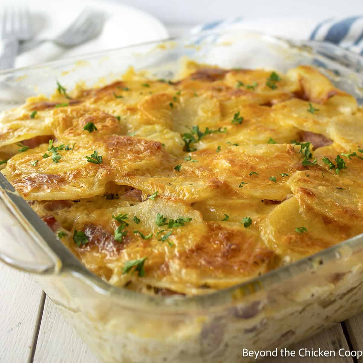 Scalloped potatoes with ham and cheese in a glass dish.