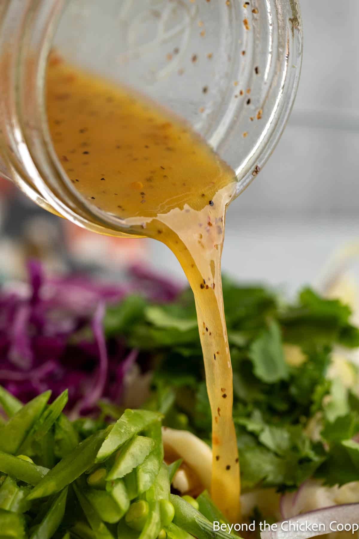 Pouring a dressing over a salad.