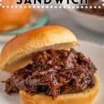 A pulled beef sandwich on a white plate.