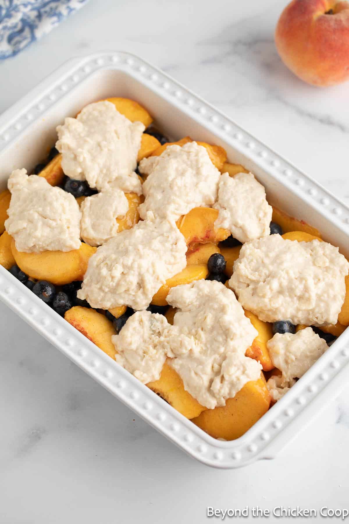 An unbaked peach and blueberry cobbler.