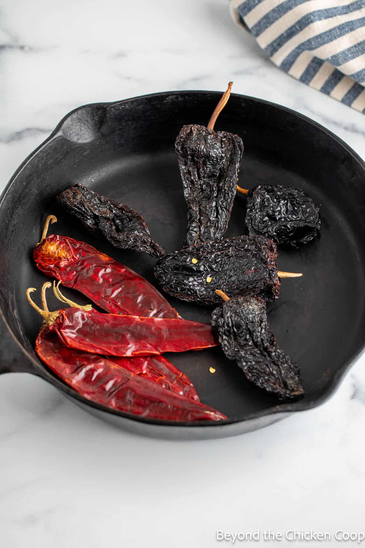 Dried chiles in a cast iron skillet.