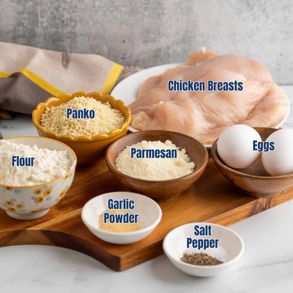 Small bowls filled with ingredients for making Parmesan chicken.
