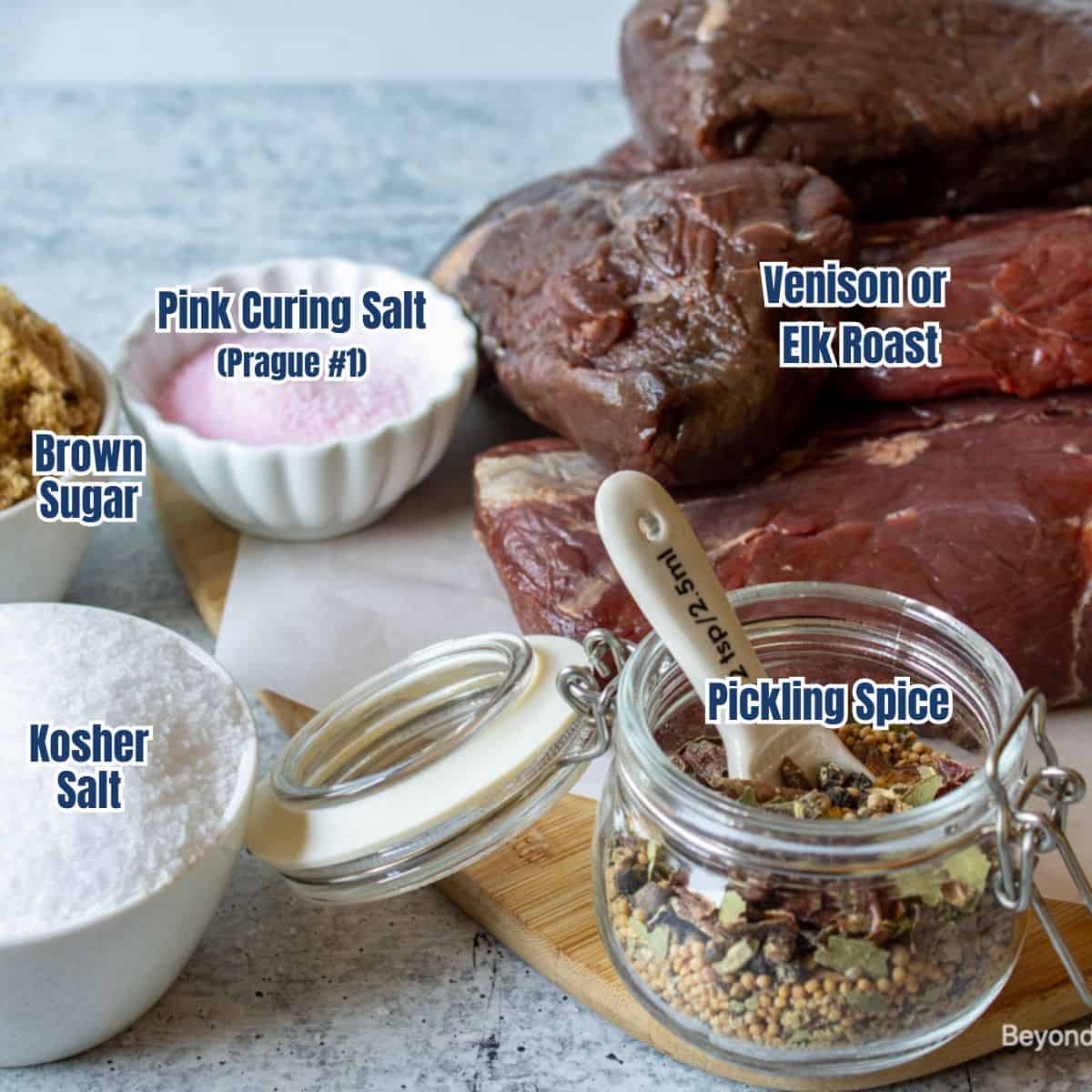 Venison roast, salt, and pickling spice on a board.