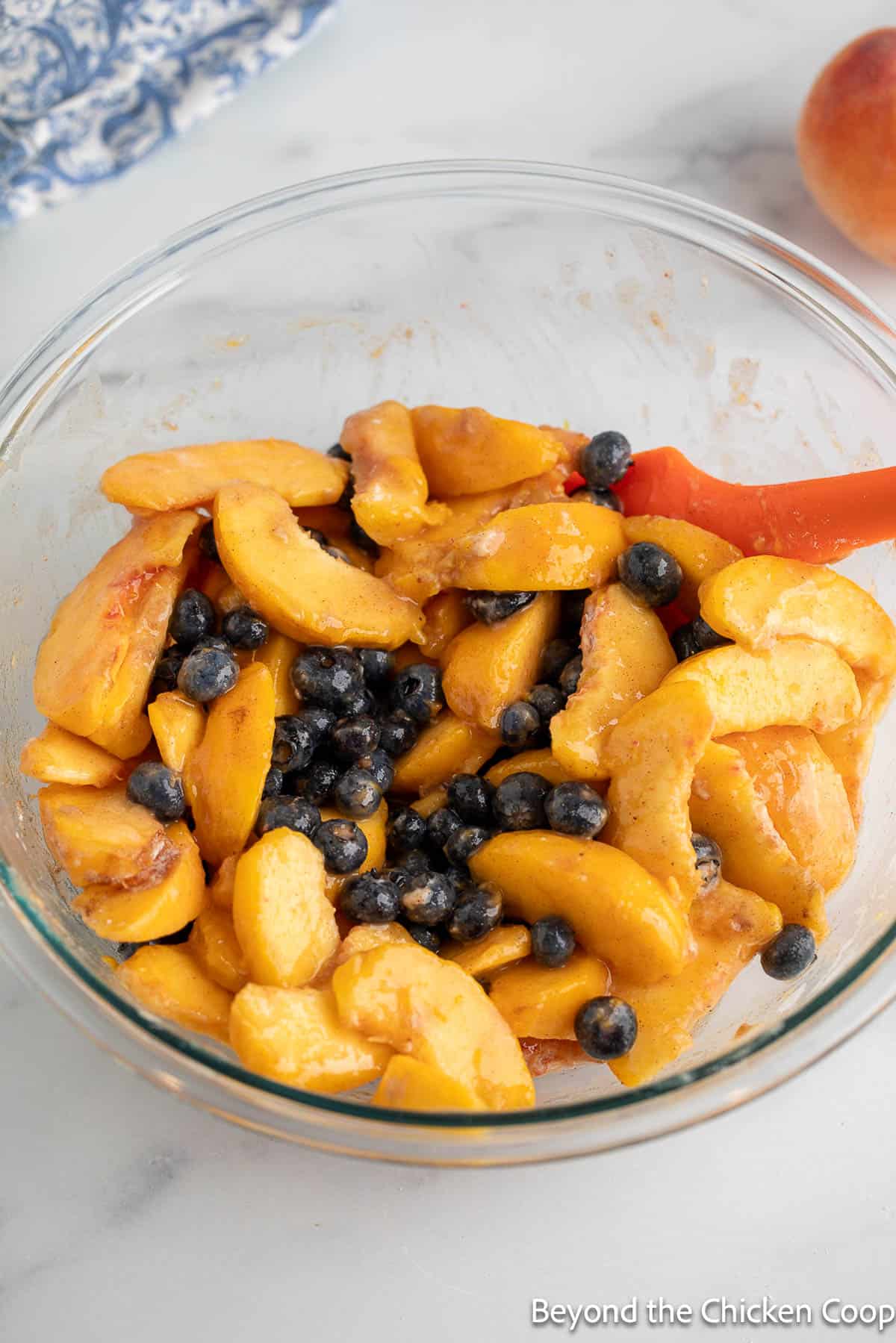 Sliced peaches and blueberries in a bowl.