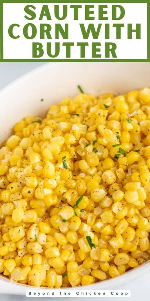 Corn kernels in a white dish topped with a bit of chopped parsley.