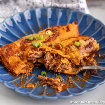 Two Shredded Beef Enchiladas on a blue plate.