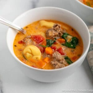 Creamy Tortellini Soup with spinach in a white bowl.