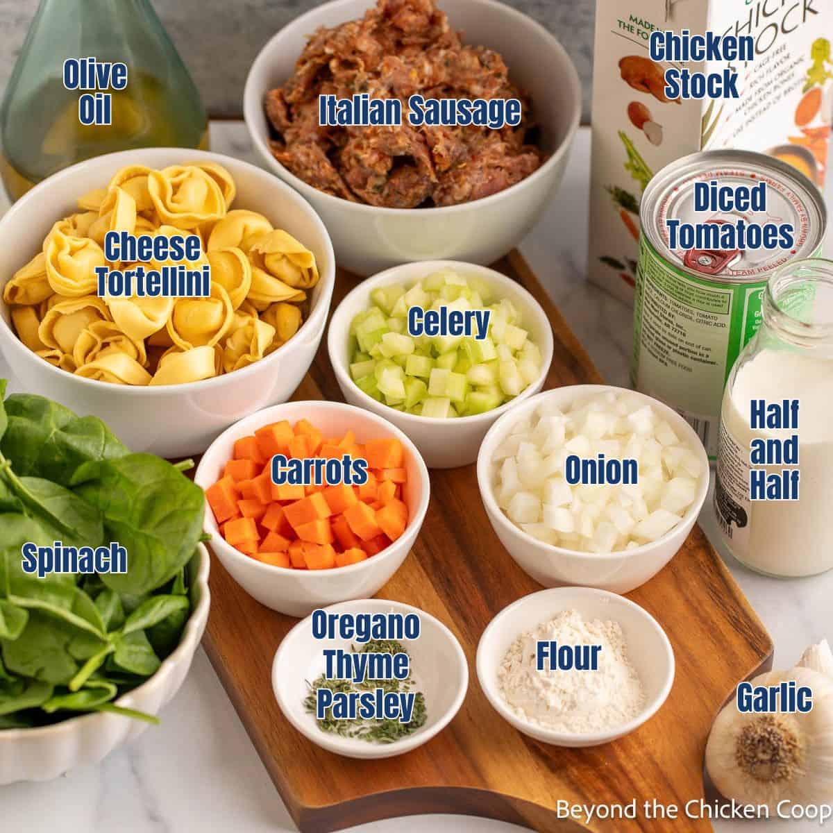 Small bowls filled with ingredients for making tortellini soup.